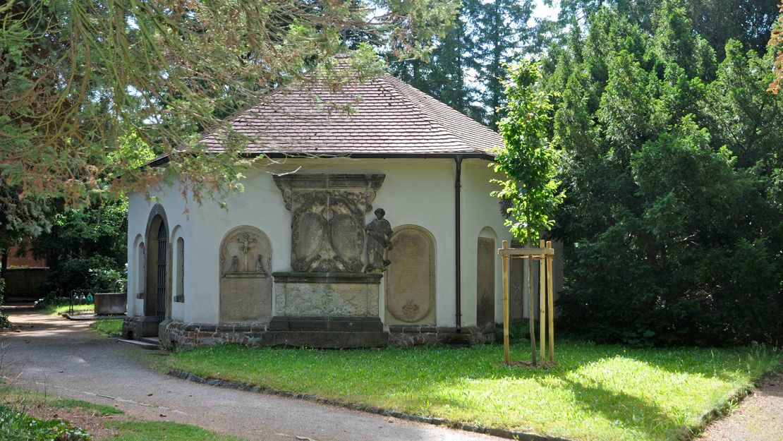 Beinhaus am Taucherfriedhof. Kleines sechseckiges Gebäude. Außenwände teils mit steinernen alten Inschriftentafeln versehen.