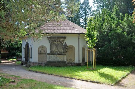 Beinhaus am Taucherfriedhof. Kleines sechseckiges Gebäude. Außenwände teils mit steinernen alten Inschriftentafeln versehen.