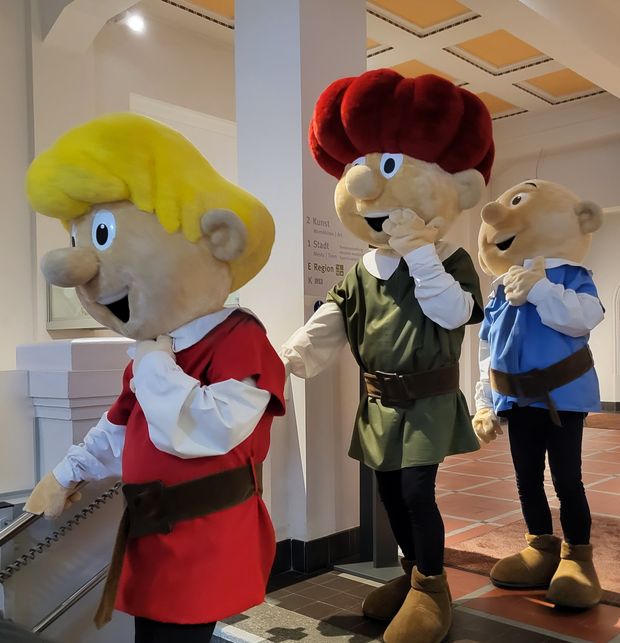 Drei Personen gehen verkleidet als die drei Abrafaxe durchs Museum Bautzen.